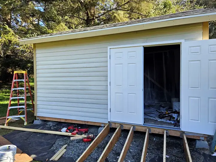 Finished shed with deck framing in progress