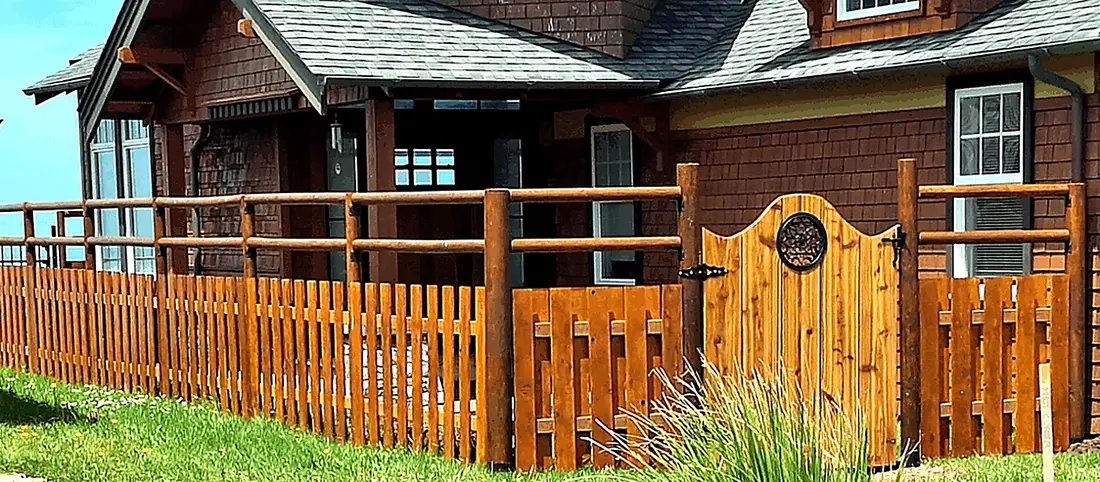 Custom wood gate and fence on a landscaped coastal property, built by SeaBreeze