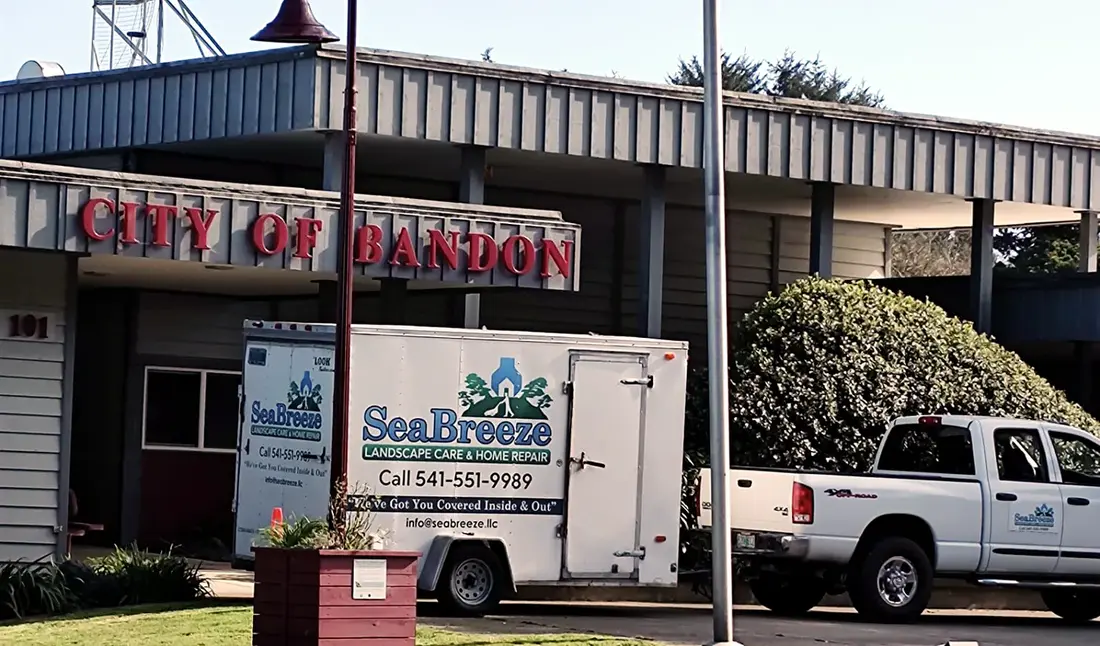 SeaBreeze truck and trailer parked outside Bandon city hall during grounds maintenance work